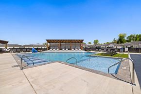 Lenoir City apartment for rent - A large outdoor swimming pool with a wooden pavilion in the background.