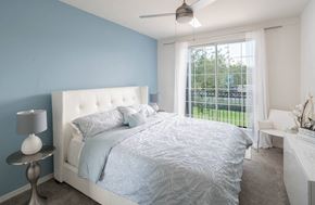 Tampa apartment for rent - a blue and white bedroom with a bed and a window