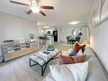 Greenville apartment for rent - A living room with a striped couch and a ceiling fan.