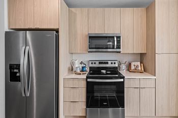 A kitchen with stainless steel appliances and wooden cabinets