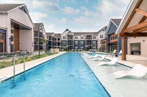 Pooler apartment for rent - A long rectangular pool with white chairs on the side.