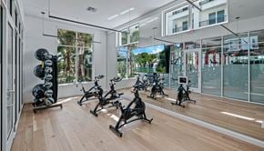 Orlando apartment for rent - the home gym has a wall of windows and a wood floor at Altis Grand Lake Willis, Orlando, 32821