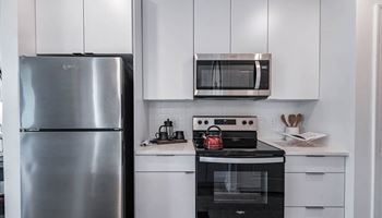 A kitchen with white appliances and a stainless steel refrigerator