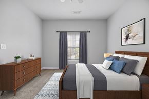 Fairburn apartment for rent - A bedroom with a large bed and a dresser.