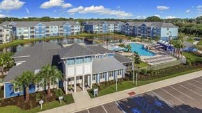 Bradenton apartment for rent - A large building with a pool in front of it.