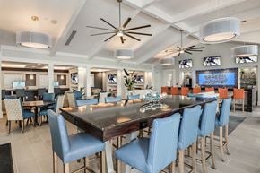 Bradenton apartment for rent - A large dining room with a long table and blue chairs.