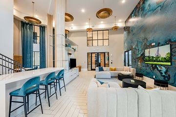 Sarasota apartment for rent - A modern living room with a bar area and a large painting on the wall.