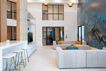 Sarasota apartment for rent - A modern living room with a white sofa and a bar area.