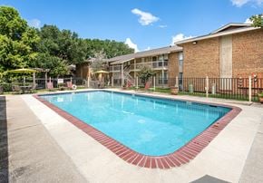 Lafayette apartment for rent - A swimming pool surrounded by a fence and trees.