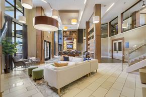 Atlanta apartment for rent - A large white couch is in the middle of a spacious room with a staircase on the right.