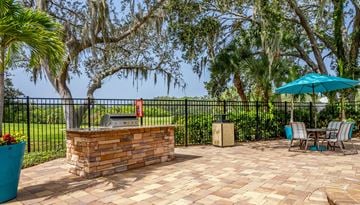 Sarasota apartment for rent - A patio with a table and chairs and a blue umbrella.