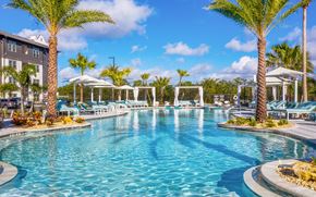 Sarasota apartment for rent - Luxury Apartments in Sarasota, FL With In-Unit Washer And Dryer - Botanic Waterside - Resort-Style Swimming Pool With Spacious Sundeck, Lounge Chairs, Umbrellas, Cabanas, And Palm Trees.