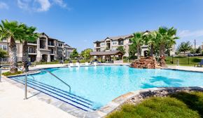 San Antonio apartment for rent - a large swimming pool with an apartment building in the background