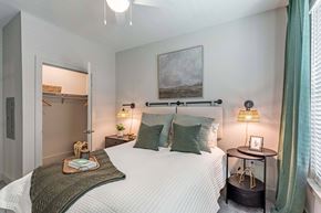Savannah apartment for rent - A bedroom with a large bed, a nightstand with a lamp, and a painting on the wall.