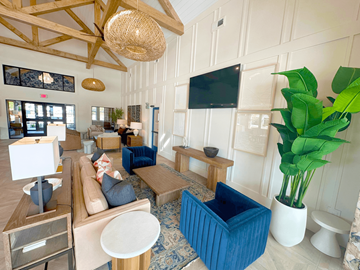 Moncks Corner apartment for rent - A living room with a blue couch and a television on the wall.