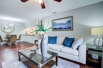 Bradenton apartment for rent - A living room with a white couch and a glass coffee table.