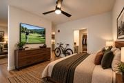 Rogers apartment for rent - A bedroom with a large bed and a TV mounted on the wall.