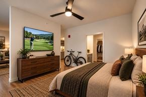 Rogers apartment for rent - A bedroom with a large bed and a TV mounted on the wall.