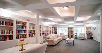 Kennesaw apartment for rent - A well-lit library with bookshelves and comfortable seating.