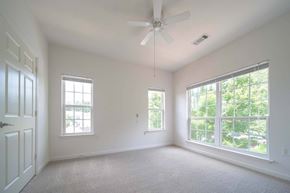 Kennesaw apartment for rent - A room with a ceiling fan and three windows.