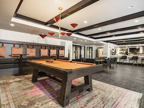 Savannah apartment for rent - A pool table in a room with a high ceiling and a rug on the floor.