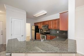 Columbus apartment for rent - A kitchen with granite countertops and wooden cabinets.