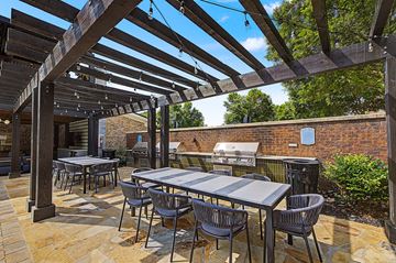 Duluth apartment for rent - A patio with tables and chairs under a wooden pergola.