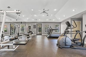 Fairburn apartment for rent - A spacious gym with a variety of equipment including treadmills, weights, and a stationary bike.