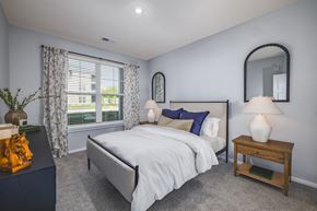 Lebanon apartment for rent - A bedroom with a large bed, a nightstand, and a window with curtains.