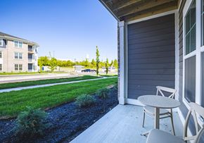 Lebanon apartment for rent - A patio with a table and chairs overlooks a grassy area and apartment buildings.
