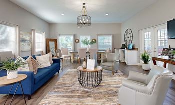 A living room with a blue sofa and white chairs