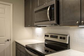 Columbus apartment for rent - A modern kitchen with a black stove top oven and microwave above it.