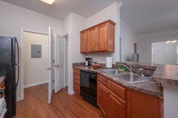 Columbus apartment for rent - A kitchen with wooden cabinets and a black refrigerator.