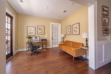 Phenix City apartment for rent - A living room with a yellow couch and a desk with a laptop.