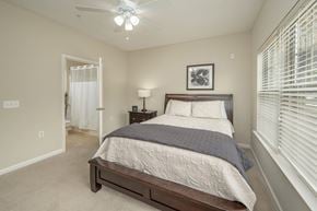 Knoxville apartment for rent - A bedroom with a bed, nightstand, and window with blinds.