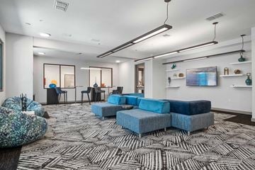 St Petersburg apartment for rent - A modern living room with a large blue sofa and a patterned carpet.
