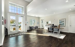 Wyoming apartment for rent - A spacious room with a wooden floor and a white rug in the center.