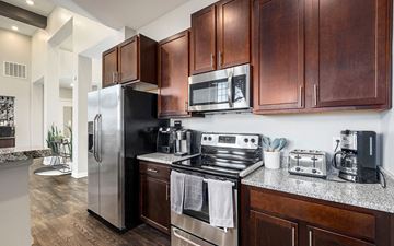Wyoming apartment for rent - A modern kitchen with dark wood cabinets and stainless steel appliances.