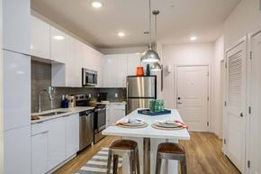 Tampa apartment for rent - A modern kitchen with a dining table set for two.