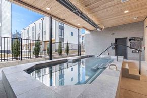 Bozeman townhouse for rent - Bozeman, MT Townhomes with In-Unit Washer and Dryer - Highmark Bozeman - Covered Spa With Clear Water, Handrail Entry, Wood Ceiling, Black Fencing, And Modern Townhome Buildings Nearby.