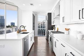 Atlanta apartment for rent - A modern kitchen with white cabinets and a view of the city.