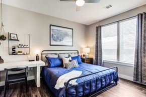 Knoxville apartment for rent - A bedroom with a blue bed and a white desk.