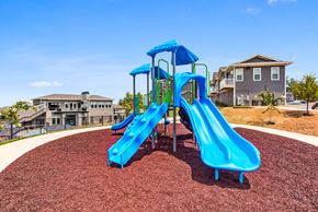 Knoxville apartment for rent - A blue playground slide in the foreground with a residential building in the background.