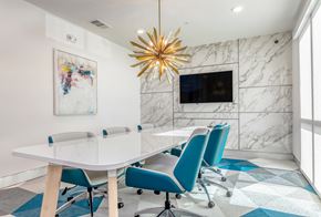Sarasota apartment for rent - A modern conference room with a white table and blue chairs.