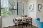 Atlanta apartment for rent - A dining room with a table set for two and a view of a building outside the window.