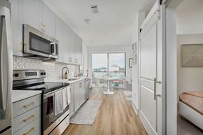 Knoxville apartment for rent - A kitchen with white cabinets and a wooden floor.