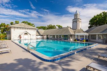 A large swimming pool in front of a building with a tower