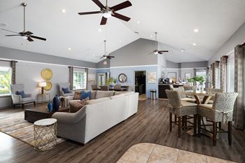 A living room with a white couch and a dining table with chairs