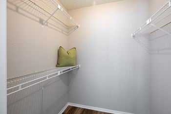 A white wall with a shelf and a pillow
