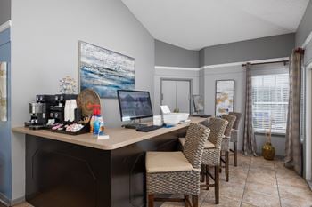 A home office with a desk, chairs, and a painting on the wall